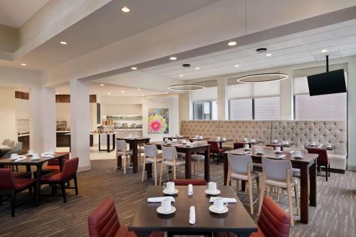 a restaurant with tables and chairs and a bar at Hilton Garden Inn Charlotte/Ayrsley in Charlotte