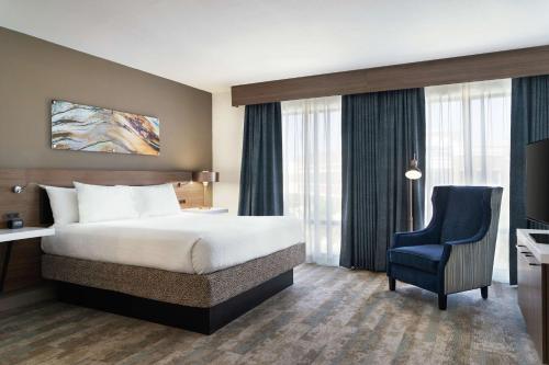 um quarto de hotel com uma cama e uma cadeira em Hilton Garden Inn Charlotte/Ayrsley em Charlotte