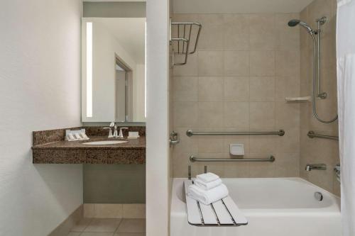a bathroom with a tub and a sink at Hilton Garden Inn Charlotte/Ayrsley in Charlotte