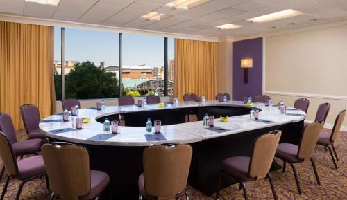 a large meeting room with a large table and chairs at Hilton Charlotte Uptown in Charlotte