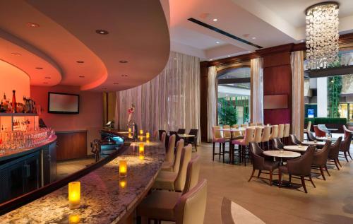 a restaurant with a bar and tables and chairs at Hilton Charlotte Uptown in Charlotte