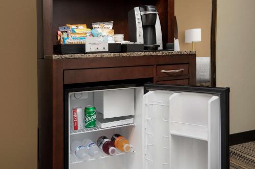 a small refrigerator with its door open in a hotel room at Hilton Garden Inn Charlotte/Mooresville in Mooresville