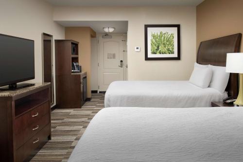 a hotel room with two beds and a flat screen tv at Hilton Garden Inn Charlotte/Mooresville in Mooresville