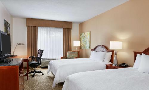 a hotel room with two beds and a television at Hilton Garden Inn Charlotte Pineville in Charlotte