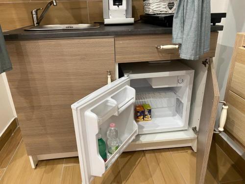 a small refrigerator with its door open in a kitchen at ToledoHomeNapoli in Naples