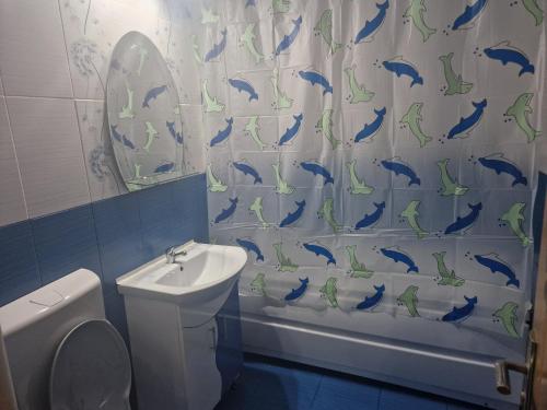 a bathroom with a shower curtain with dolphins on it at Stefan in Călimăneşti