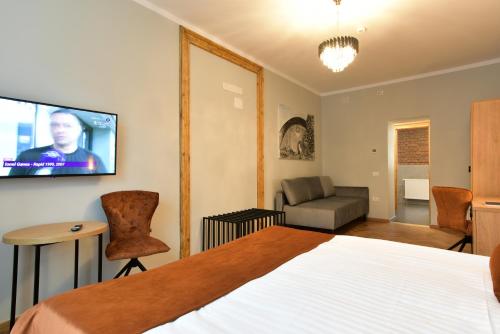a bedroom with a bed and a flat screen tv at Prinz Gregor in Braşov