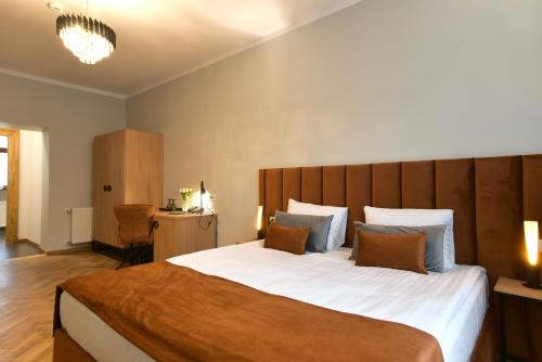 a bedroom with a large bed with a wooden headboard at Prinz Gregor in Braşov