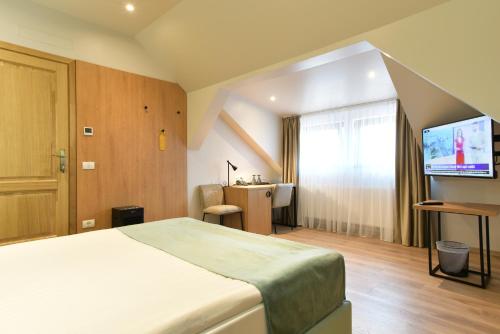 a hotel room with a bed and a flat screen tv at Prinz Gregor in Braşov