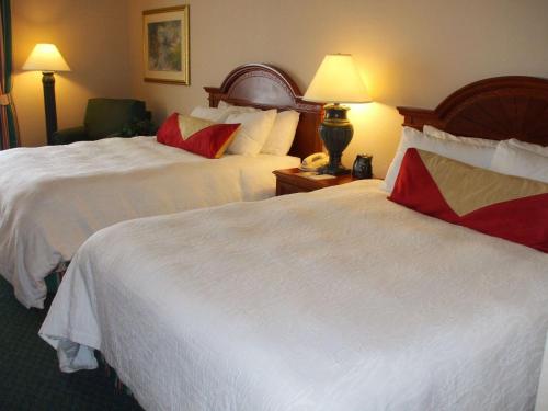 a hotel room with two beds with white sheets at Hilton Garden Inn Columbus Airport in Columbus