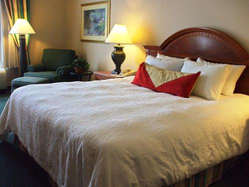 a hotel room with a large bed and a chair at Hilton Garden Inn Columbus Airport in Columbus