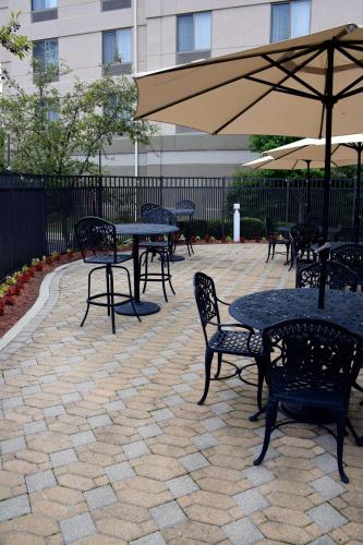 a group of tables and chairs with an umbrella at Hilton Garden Inn Columbus/Polaris in Columbus
