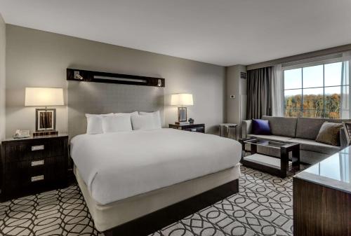 a hotel room with a large bed and a couch at Hilton Columbus at Easton in Columbus