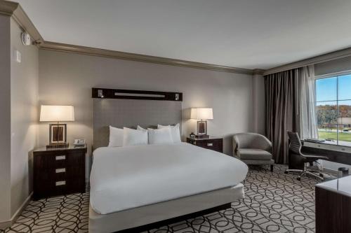 a hotel room with a large bed and a desk at Hilton Columbus at Easton in Columbus