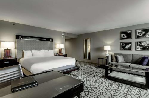 a large hotel room with a bed and a couch at Hilton Columbus at Easton in Columbus
