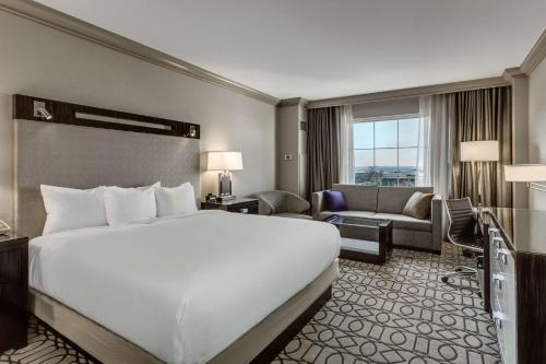 a hotel room with a large bed and a living room at Hilton Columbus at Easton in Columbus