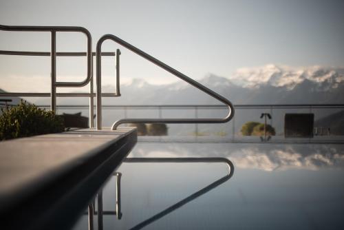 a swimming pool with a view of snow covered mountains at DAS GERSTL Alpine Retreat in Malles Venosta