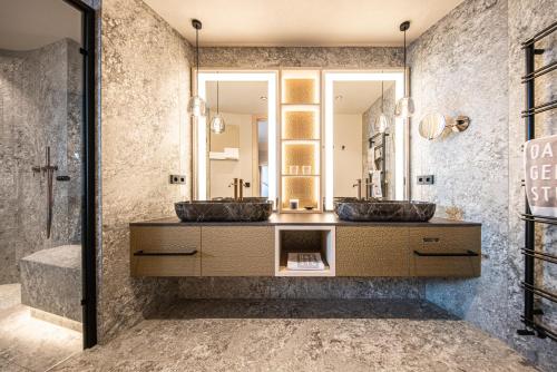 a bathroom with two sinks and a mirror at DAS GERSTL Alpine Retreat in Malles Venosta