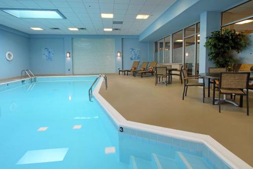 una piscina en una habitación con sillas y mesas en Doubletree by Hilton Newark en Newark