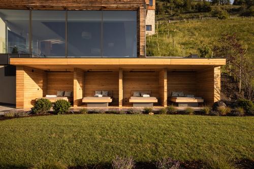 a building with benches on the side of a yard at DAS GERSTL Alpine Retreat in Malles Venosta