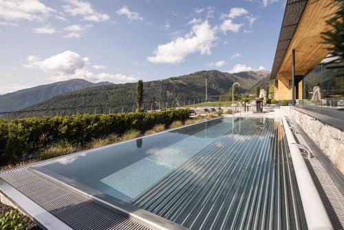 a swimming pool on top of a house with mountains at DAS GERSTL Alpine Retreat in Malles Venosta