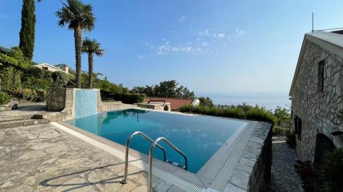 a swimming pool in a house with the ocean in the background at Mountains Villa near Budva in Budva