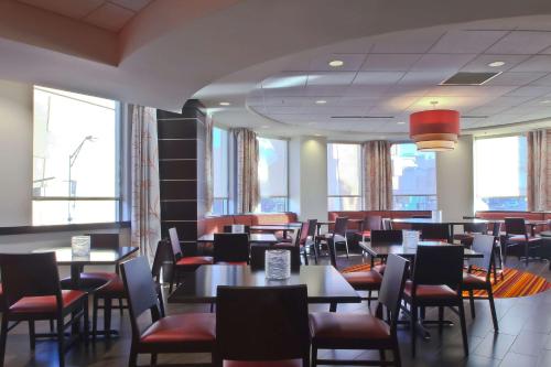 a dining room with tables and chairs and windows at Hampton Inn & Suites Columbus-Downtown, Ohio in Columbus