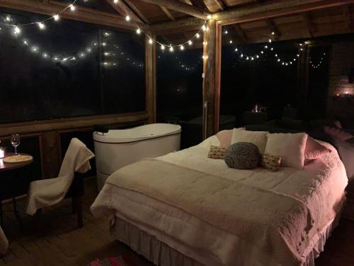 sypialnia z łóżkiem, wanną i światłami w obiekcie Montanha Home w mieście Monte Verde