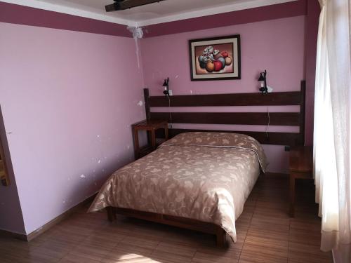 a bedroom with a bed and a picture of apples on the wall at Cruz Popayan Sucre in Sucre