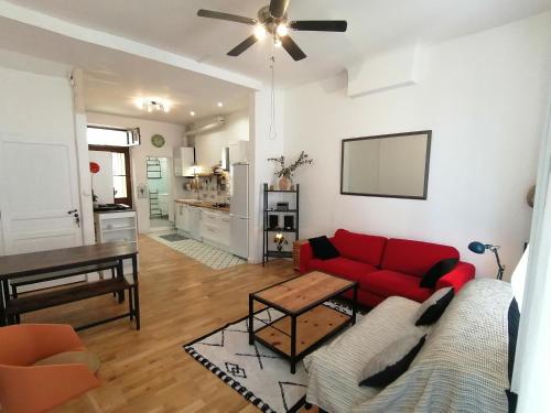 un salon avec un canapé rouge et une table dans l'établissement Jolie maison avec terrasse au centre-ville d'Arles, à Arles