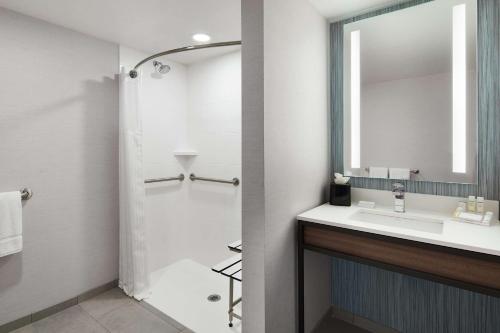 y baño con lavabo y espejo. en Hilton Garden Inn Champaign/ Urbana, en Champaign