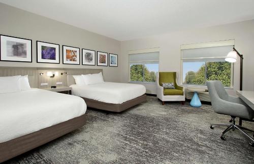 een hotelkamer met 2 bedden, een bureau en een stoel bij Hilton Garden Inn Columbus-University Area in Columbus