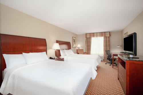 a hotel room with two beds and a flat screen tv at Hilton Garden Inn Casper in Casper