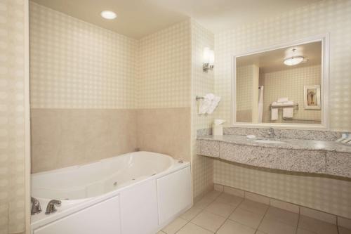 a bathroom with a tub and a sink and a mirror at Hilton Garden Inn Casper in Casper