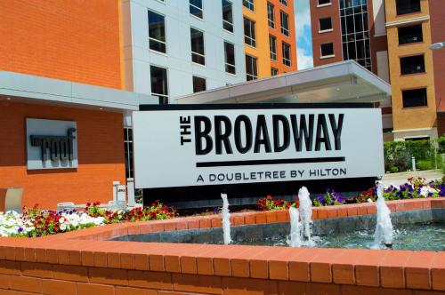 a sign in front of a fountain in front of a building at The Broadway Columbia - a DoubleTree by Hilton Hotel in Columbia