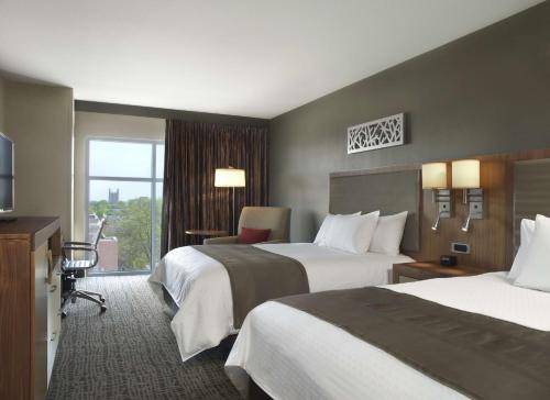 a hotel room with two beds and a window at The Broadway Columbia - a DoubleTree by Hilton Hotel in Columbia