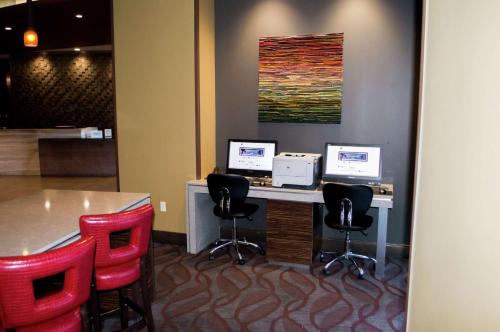 an office with two computers on a desk with red chairs at The Broadway Columbia - a DoubleTree by Hilton Hotel in Columbia