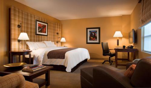 a hotel room with a bed and a living room at DoubleTree by Hilton Cincinnati Airport in Hebron