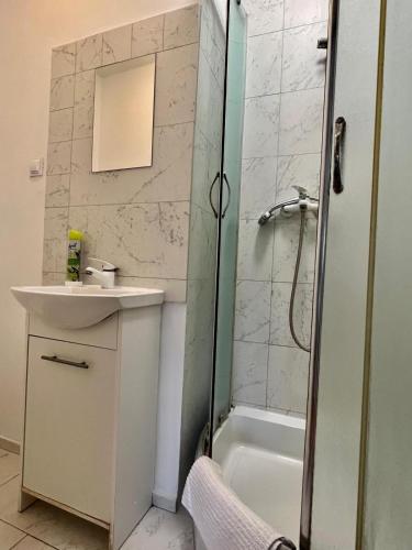 a bathroom with a shower and a sink and a tub at Familly Apartament 3 in Międzyzdroje