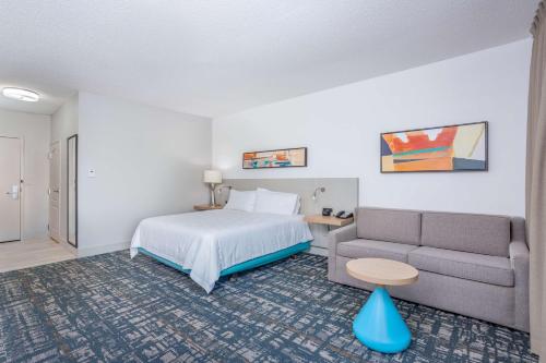 a hotel room with a bed and a couch at Hilton Garden Inn Cincinnati/Sharonville in Sharonville