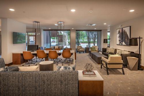 a living room with couches and a table and chairs at DoubleTree by Hilton Dallas-Farmers Branch in Farmers Branch