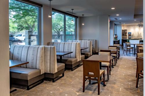 a restaurant with chairs and tables and windows at DoubleTree by Hilton Dallas-Farmers Branch in Farmers Branch