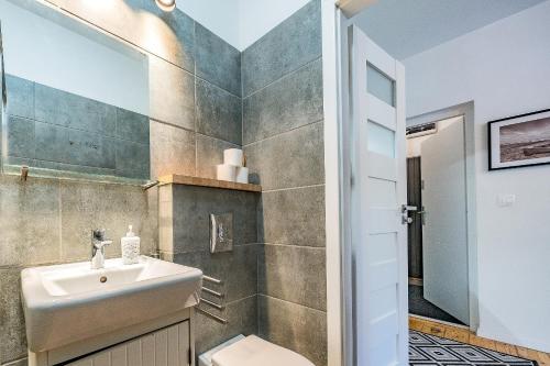 La salle de bains est pourvue d'un lavabo et de toilettes. dans l'établissement Pomorskie Apartamenty Enter House, à Sopot