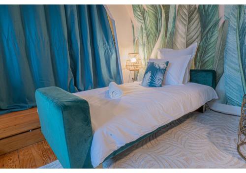 uma cama num quarto com cortinas azuis e brancas em Le Cocon de la Cathédrale em Évreux