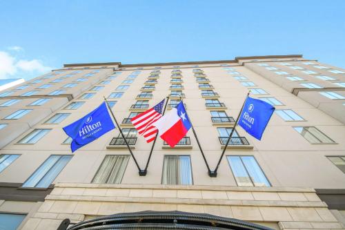 three flags on the front of a building at Hilton Dallas-Park Cities in Dallas