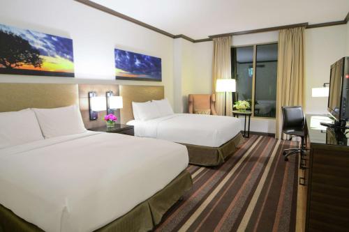 a hotel room with two beds and a flat screen tv at Hilton Dallas-Park Cities in Dallas