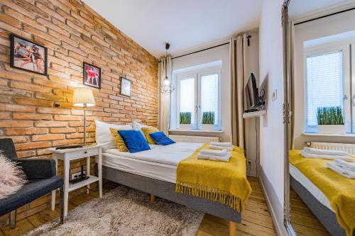 ソポトにあるPomorskie Apartamenty Enter Houseのレンガの壁、ベッド2台が備わるベッドルーム1室が備わります。