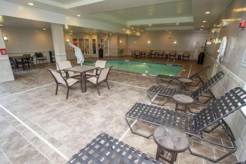 a pool with tables and chairs in a hotel lobby at Hilton Garden Inn Dayton South - Austin Landing in Springboro