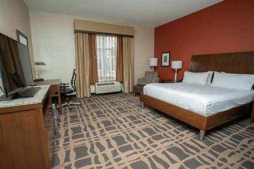 a hotel room with a bed and a flat screen tv at Hilton Garden Inn Dayton South - Austin Landing in Springboro