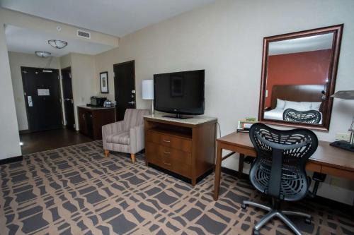 a hotel room with a desk with a television and a chair at Hilton Garden Inn Dayton South - Austin Landing in Springboro